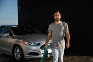 Front view, job is done, polished... Man is with his car outdoors photo