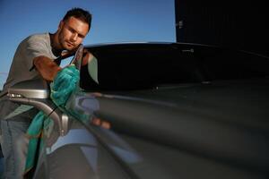 Working, polishing t,he automobile. Man is with his car outdoors photo