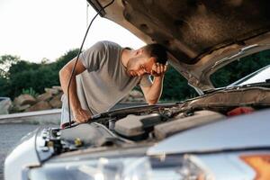 Trying ,to ,repair ,,the broken automobile. Man is with his car outdoors photo