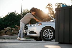 Beautiful ,sunlight,. Hood ,is ,,opened, guy is repairing the automobile. Man is with his car outdoors photo