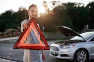 Broken, car, red ,,sign. Man is with his automobile outdoors photo