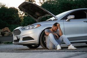 Accident, broken, automobile,,, is parked. Man is with his car outdoors photo