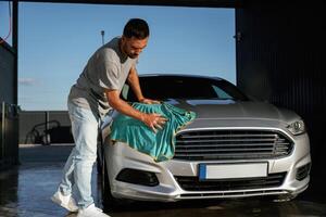 Turquoise cloth, polishing the vehicle...., Man is with his car outdoors photo