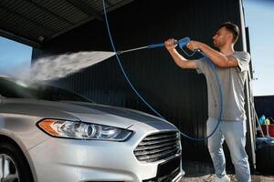 Side, view,, car wash, high pressure. Man is with his automobile outdoors photo