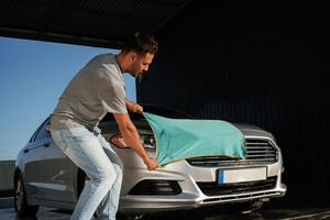 Cloth, ,cleaning ,the, automobile. .Man is with his car outdoors photo