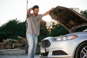 Problem, fixing ,and repairing the broken automobile. Man is with his car outdoors photo