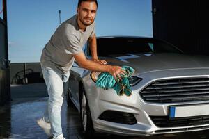 Business ,,of car washing, polishing. Man is with automobile outdoors photo