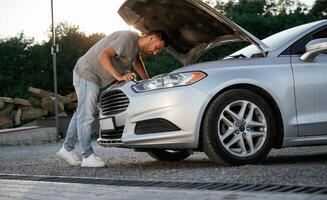 Problem,, fixing and repairing the broken automobile. Man is with his car outdoors photo