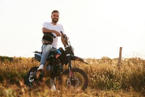 Man, is on the motorcycle is on the field, outdoors photo