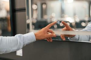 Close up view, touching smart mirror. Man is in the hardware shop photo