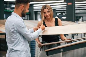 Making,,, fun, color of parquet is the same as girlfriend hair. Man with woman are in the hardware store photo