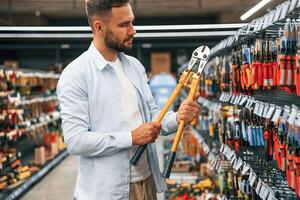 With garden shears,. Man is in the hardware shop photo