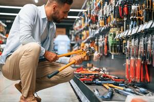 With, garden shears. Man is in the,hardware shop photo