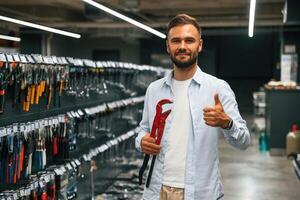 Red plumbing wrench. Man ,,is in the, hardware shop photo