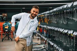Stealing the wrench, smiling. Man is in the hardware shop photo