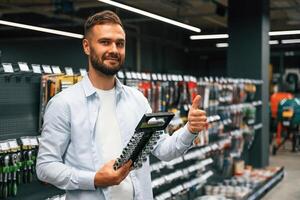 Selecting ,,the new equipment. Man is in the hardware shop photo