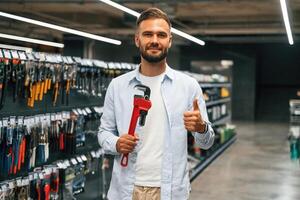 Red plumbing, wrench. Man is in the hardware shop photo