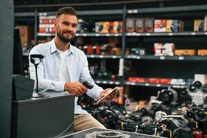 Cashier, is at work. Man is in the hardware shop photo