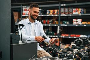 Cashier, is, at work. Man is in the hardware shop photo