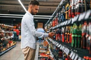 Searching, for,, the tools. Man is in the hardware shop photo