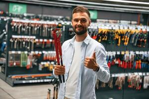 Red, plumbing,, wrench. Man is in the hardware shop photo