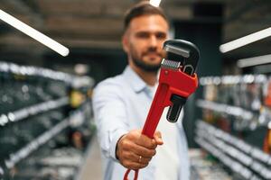 Red ,,plumbing wrench. Man is in the hardware shop photo