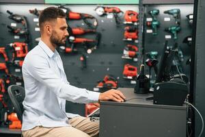 Cashier is, at,, work. Man is in the hardware shop photo