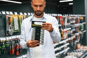 Selecting the new equipment. Man, is ,in the hardware shop photo