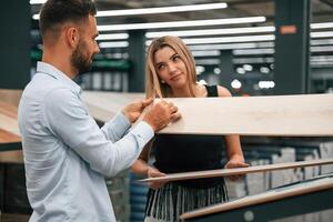 Making, fun, color,,, of parquet is the same as girlfriend hair. Man with woman are in the hardware store photo