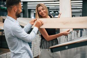 Making fun,, color of parquet is the same as girlfriend hair. Man with woman are in the hardware store photo