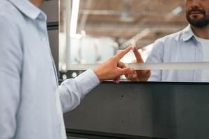 Touching, trying ,smart ,mirror. Man is in the hardware shop photo