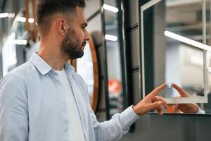 Smart, mirror,,, touching it. Man is in the hardware shop photo
