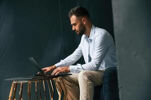 Focused,, confident. Businessman ,is sitting and working by using laptop photo