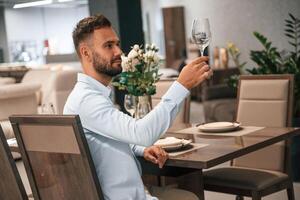 Man is ,sitting, in the restaurant with tasty alcohol drink photo