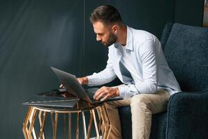 Focused, confident. Businessman, is, sitting and working by using laptop photo
