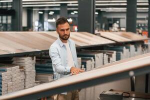 Warehouse with, big choice of parquet. Man is in the hardware shop photo