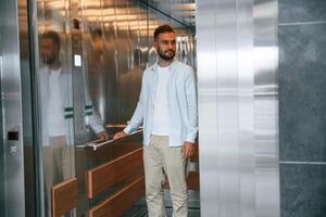 Man ,in formal clothes is indoors, elevator photo
