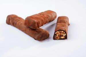 Brown, colored chocolate bars lie on a white surface, isolated photo