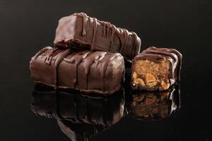 Close, up view. Crispy and sweet chocolate, bars on black background photo
