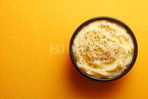 Mashed potatoes in a bowl on a yellow background photo