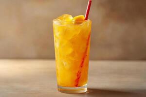 A glass of orange juice with a red straw photo