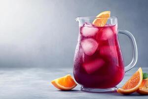 A pitcher of red sangria with oranges and ice photo