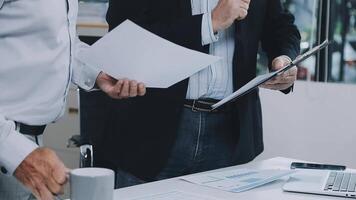 Two men in business attire are standing around a table with papers video