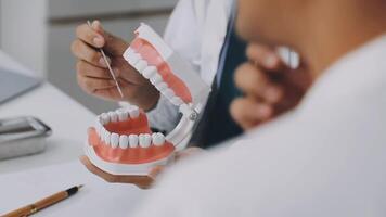 A man is holding a tooth model in front of his mouth video