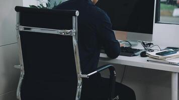 A man sitting at a desk with a computer and a chair video