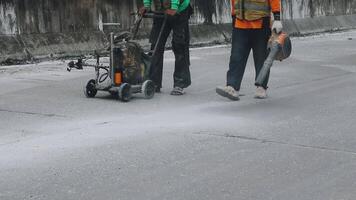Two men using a machine to clean the road video