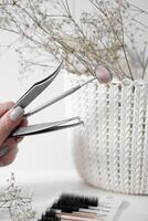 Elegant Dental Tools with Floral Decor A minimalist composition featuring pink and clear mascara wands arranged on a light surface, accompanied by delicate white flowers, creating a soft and elegant photo