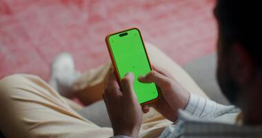 A man in casual clothes typing on a mobile phone photo