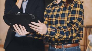 Two people standing next to each other holding a tablet video