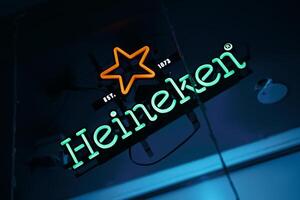 View of Heineken neon light sign at a pub. Heineken is a Dutch brewing company, founded in 1864 by Gerard Adriaan Heineken in Amsterdam. BISHKEK, KYRGYZ REPUBLIC - 25 JULY 2021 photo